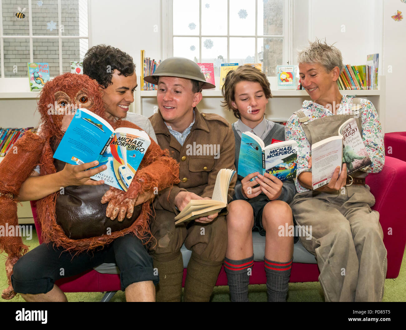 Edinburgh Fringe Festival, Édimbourg, Royaume-Uni. 7 août 2018. Bibliothèque centrale, Édimbourg, Écosse Royaume-Uni : une séance de photos pour les spectacles du Fringe basé sur les livres pour enfants par Michael Morpurgo. Scamp Theatre secteur paisible, avec Andy Daniel, Production Poonamallee un éléphant dans le jardin avec Lizzie joué par Alison Reid ; Aquila La Guerre de Jenkin's Ear avec Toby Jenkins joué par Atticus et Christie-Miller Production WildChild Kensuke's Kingdom avec Michael joué par Aaron Douglas ; bibliothèque pour enfants avec des acteurs la lecture de livres Banque D'Images
