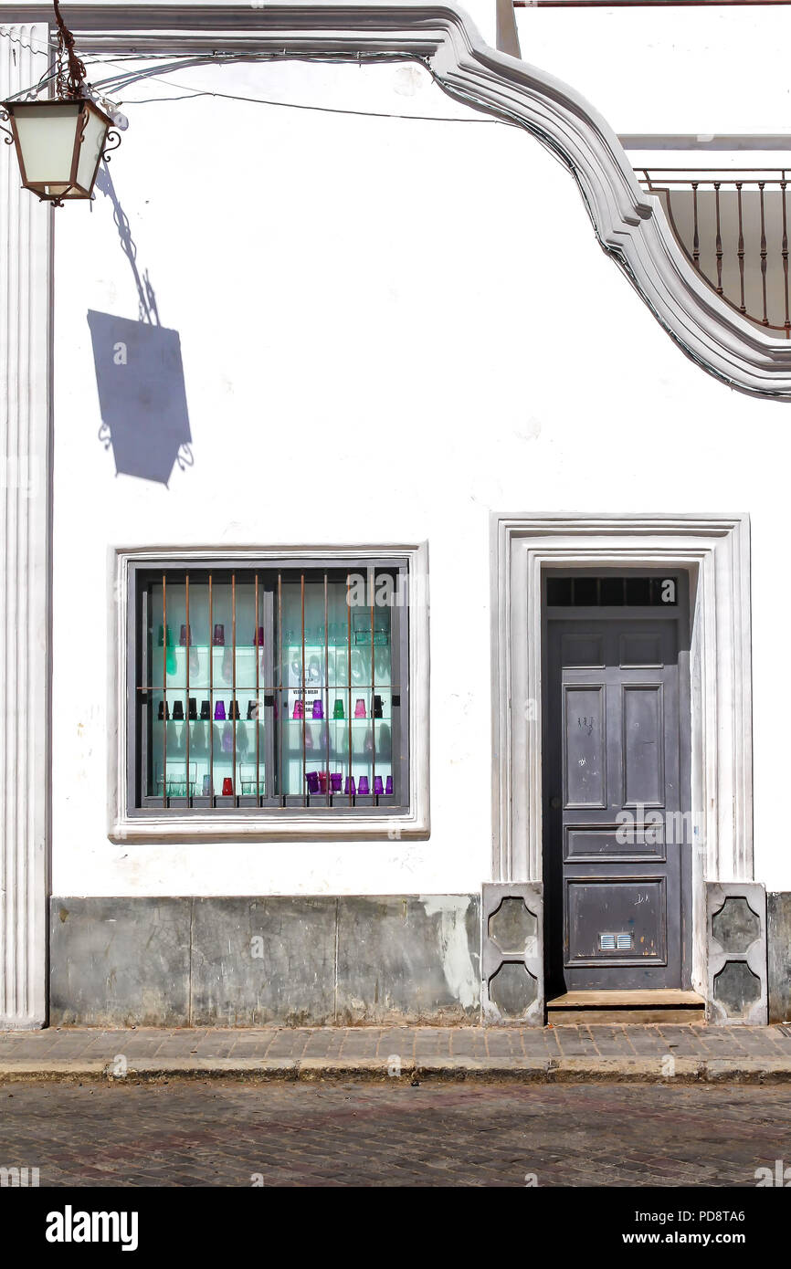 Mur Blanc brillant d'un bâtiment construit dans un style traditionnel portugais. Boutique avec une fenêtre avec des verres colorés. Vieille lanterne. Rue de l'ancien portugais Banque D'Images