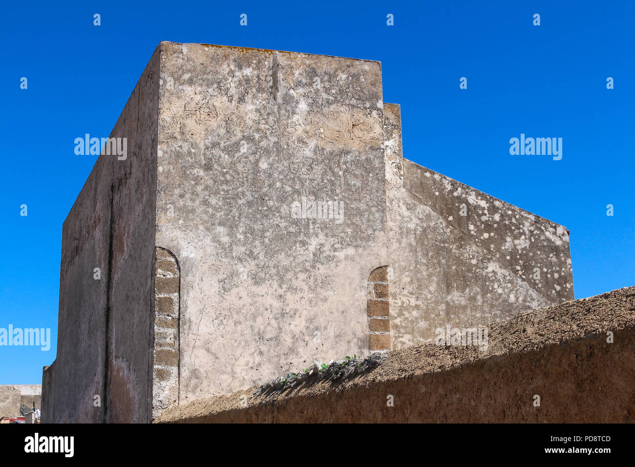 La ligne d'une fortification clôture. Chambre avec murs altérés et sans fenêtres. Ciel bleu. El Jadida, Maroc. Banque D'Images