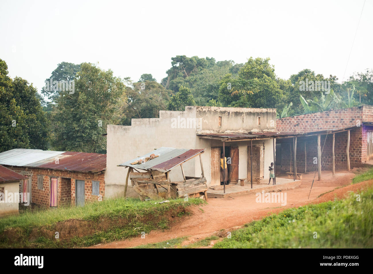 Boutiques et maisons bordent la route d'une petite ville rurale dans le district de Mukono, en Ouganda. Banque D'Images