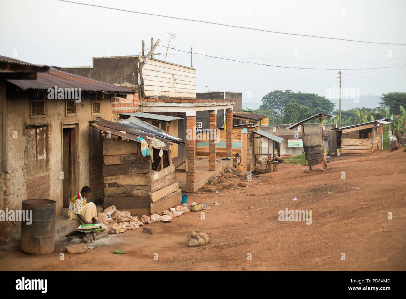 Boutiques et maisons bordent la route d'une petite ville rurale dans le district de Mukono, en Ouganda. Banque D'Images