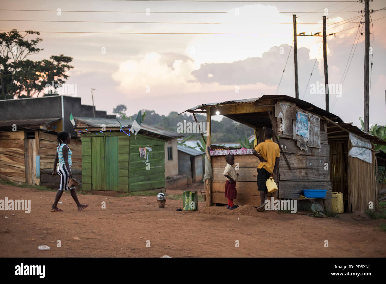 Boutiques et maisons bordent la route d'une petite ville rurale dans le district de Mukono, en Ouganda. Banque D'Images