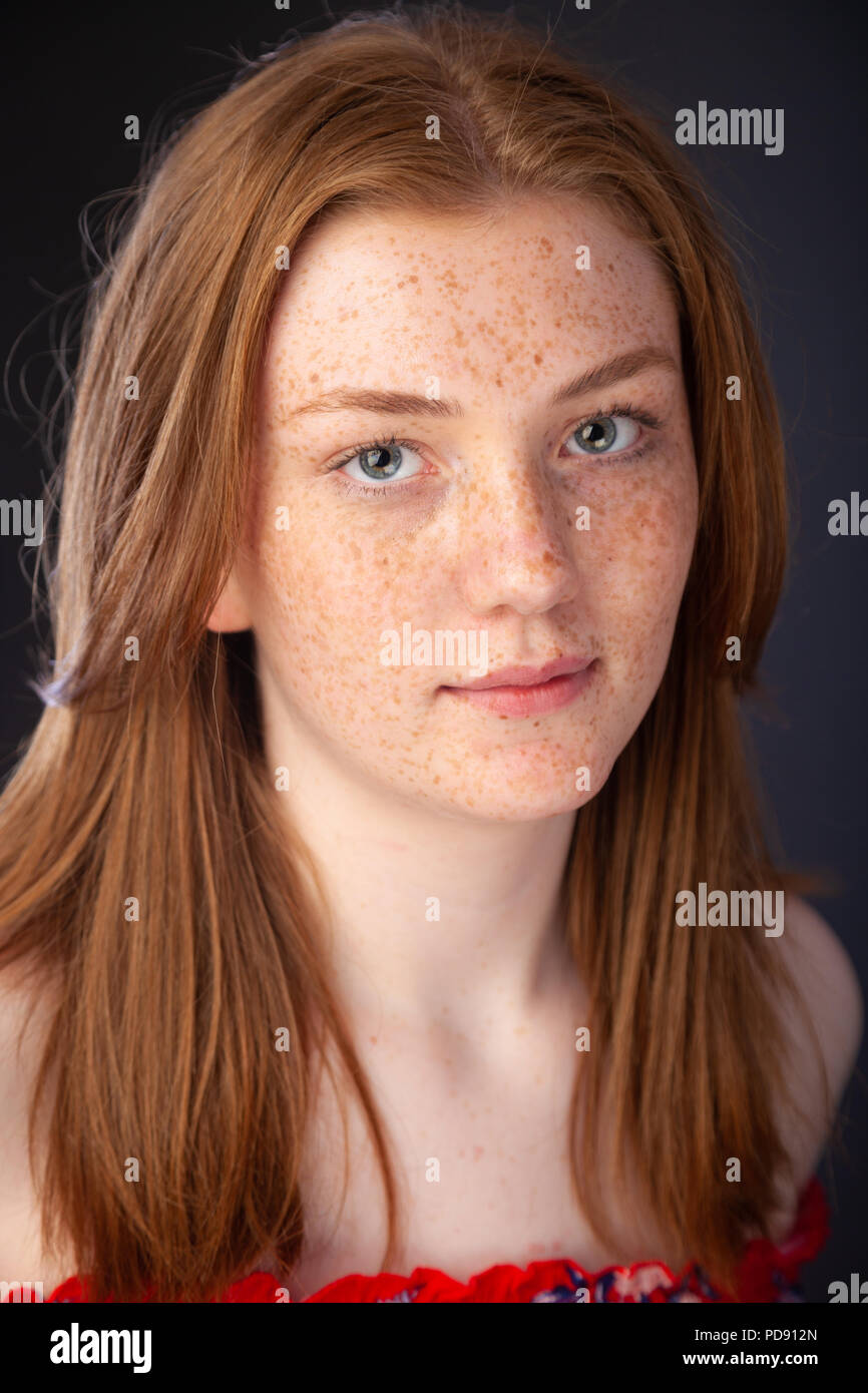 Portrait d'une jolie adolescente aux cheveux roux et taches de rousseur à la recherche vers la caméra. Banque D'Images