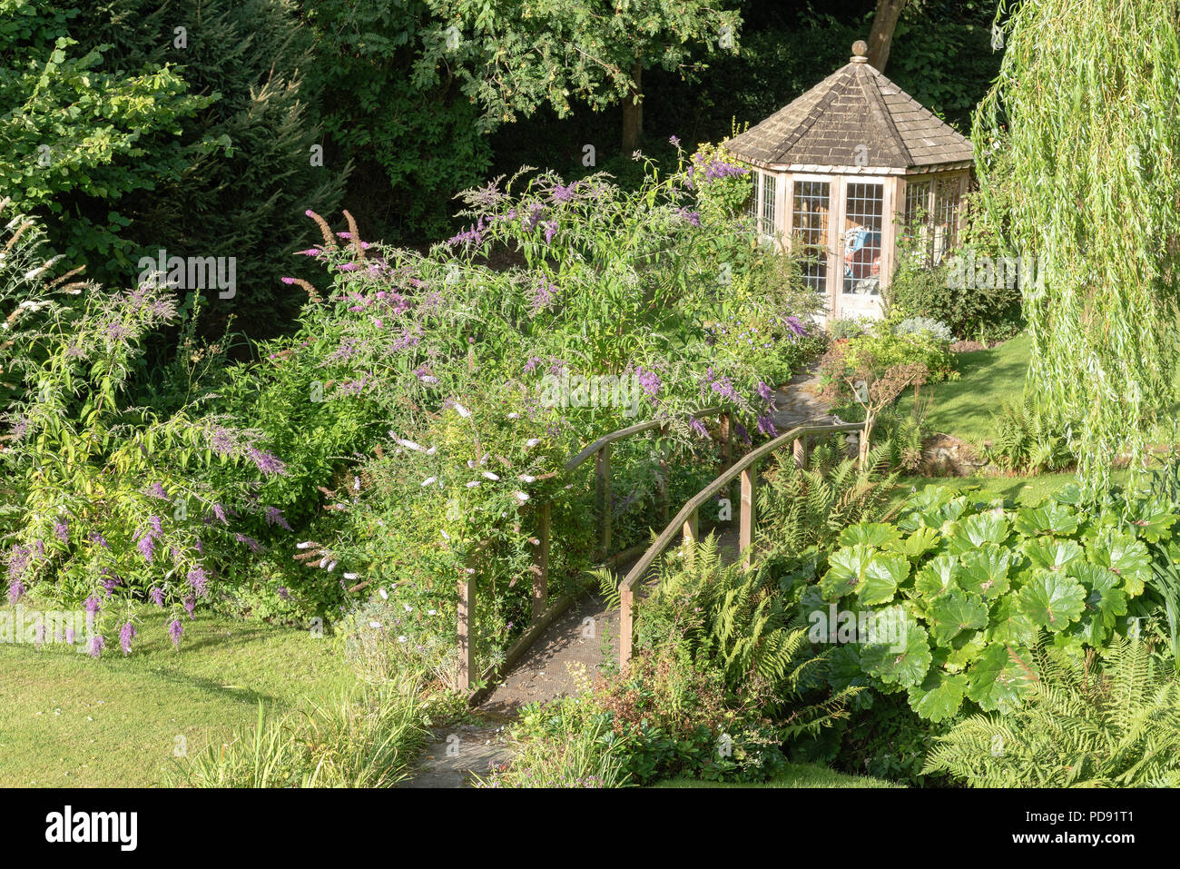 Sommaire d'une maison d'été et pont en bois dans un jardin de campagne anglaise Banque D'Images