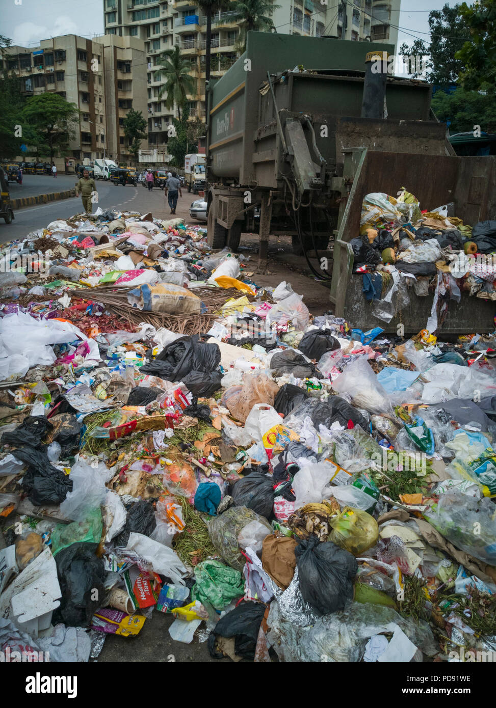 Des sacs en plastique remplis de déchets ménagers se trouvent sur rue à côté de poubelle à Mumbai, Inde Banque D'Images