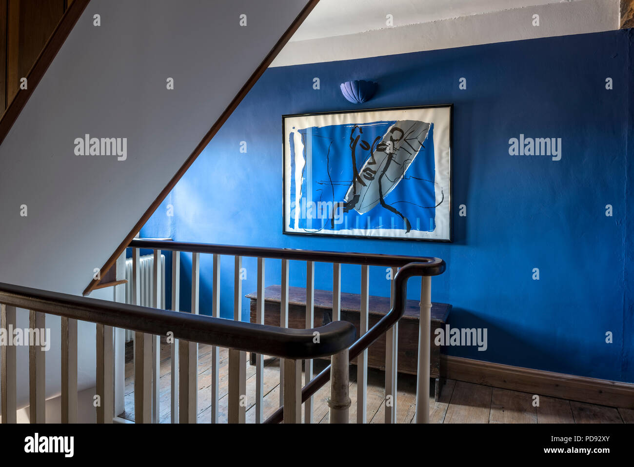 Premier étage palier avec les murs peints en bleu solide Banque D'Images