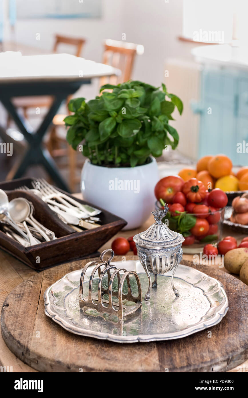 Le basilic, tomates et de l'argenterie sur la table de cuisine Banque D'Images