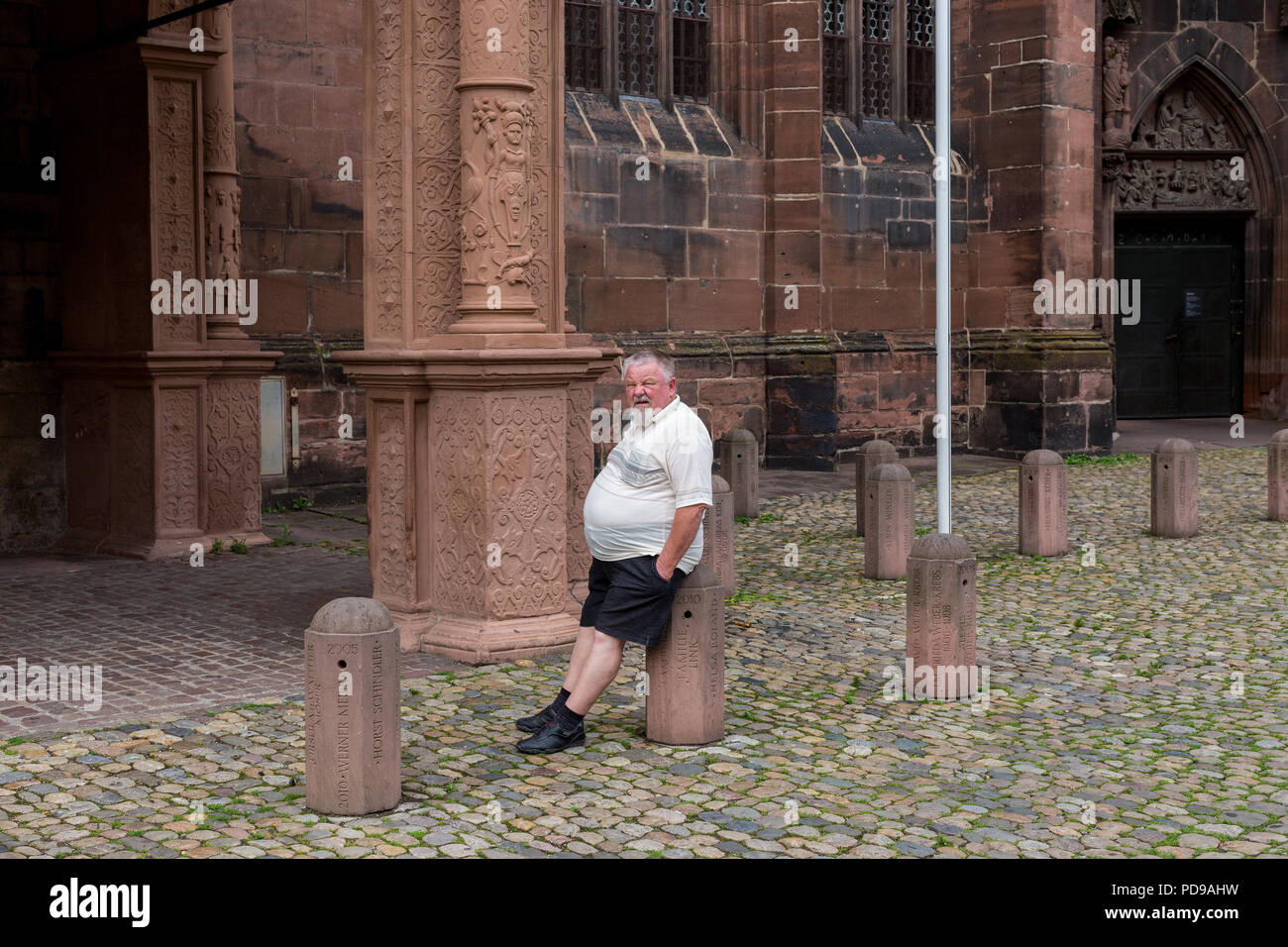 Un touriste s'ennuie en attente devant un bâtiment historique en Europe en Allemagne Banque D'Images