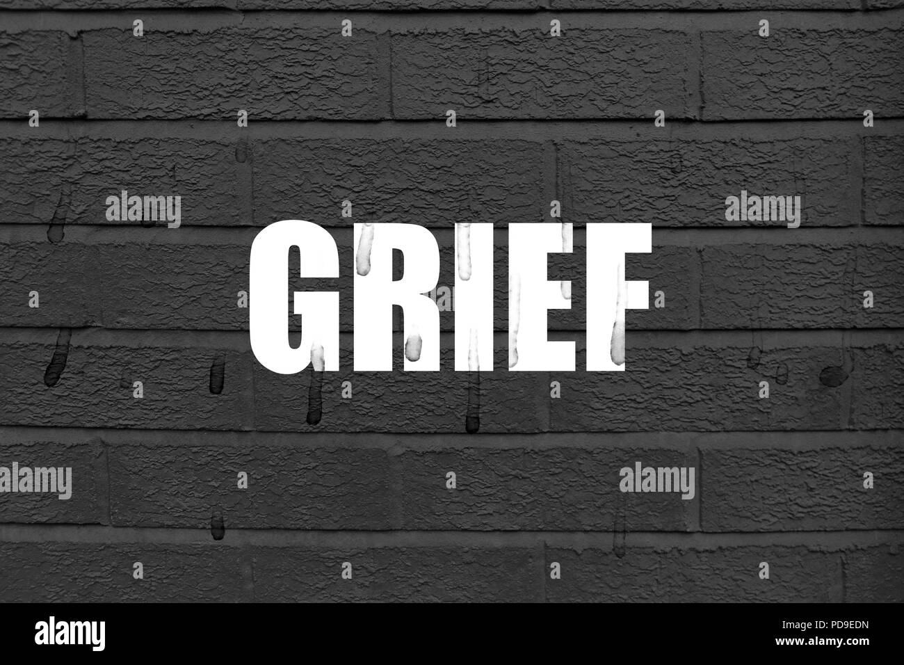 Mot 'Chagrin' sur l'arrière-plan noir avec des sentiers de larmes sur les lettres blanches et l'arrière-plan Banque D'Images