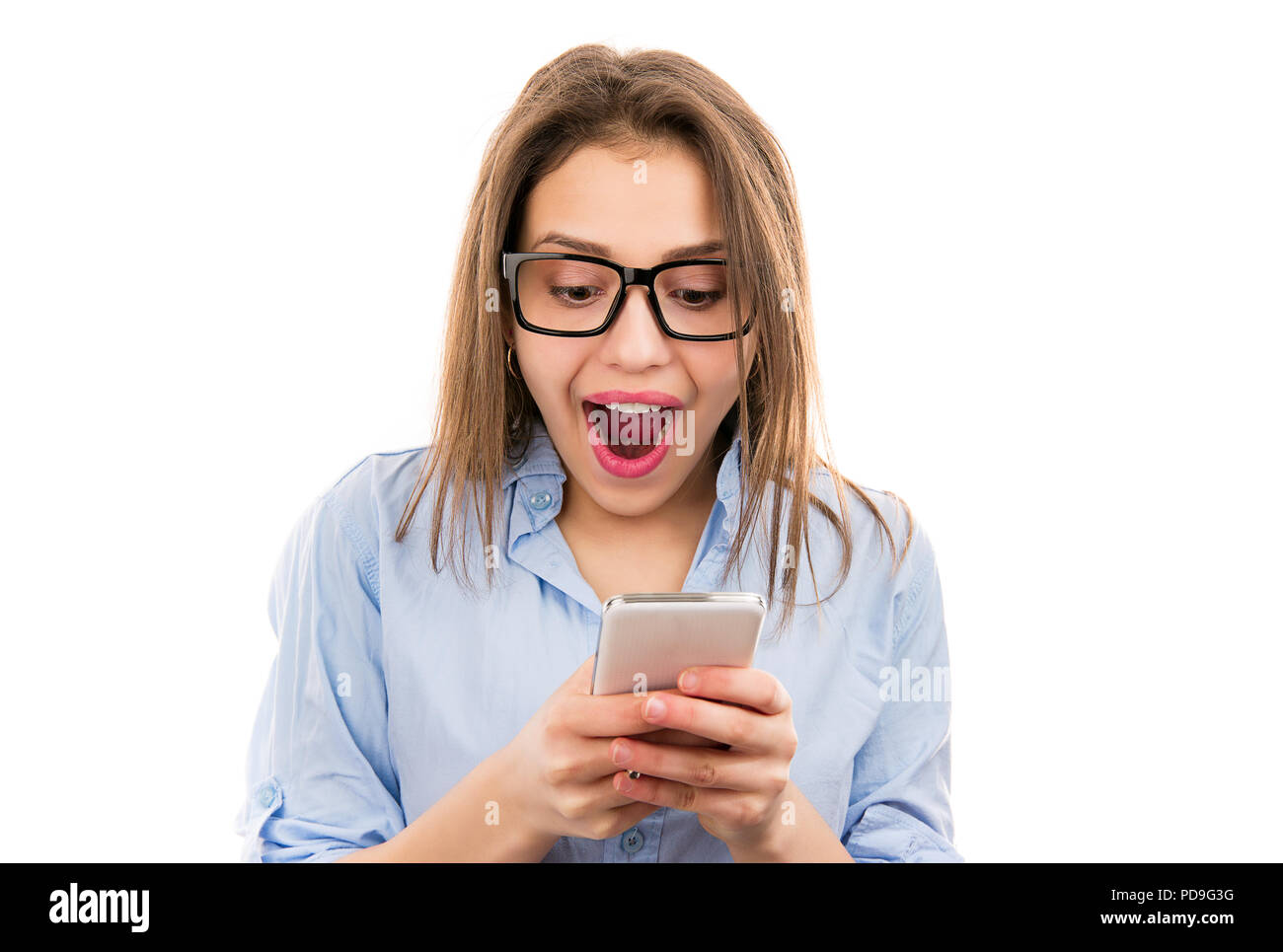 Jeune femme surprise lumineuse dans les verres looking at smartphone et la lecture nouvelle choquante isolé sur fond blanc Banque D'Images