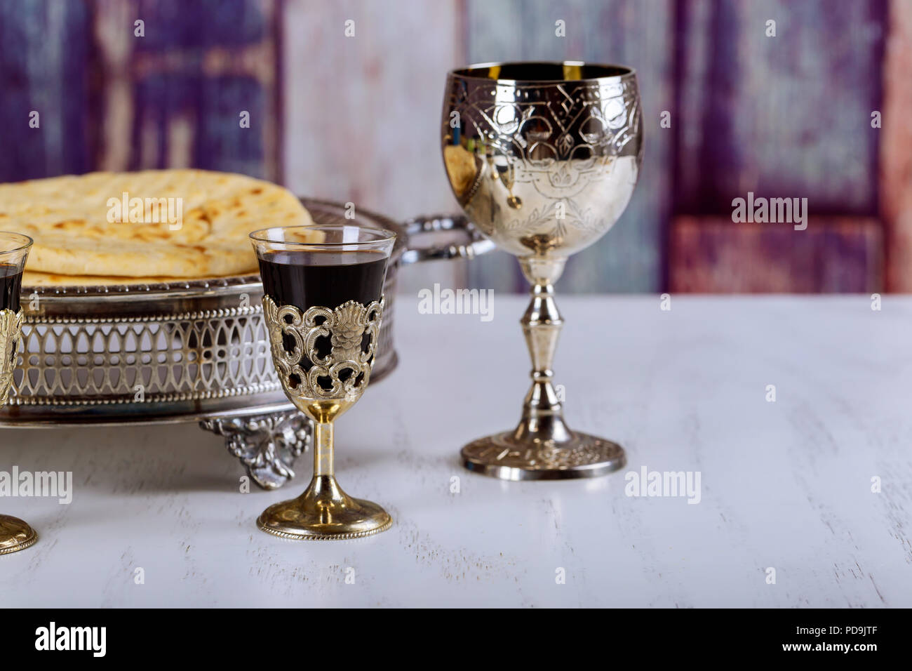 Prendre la communion. Tasse de verre avec du vin rouge, du pain sur la table en bois close-up. L'accent sur le vin Banque D'Images