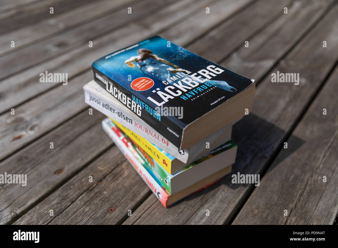 Pile de livres - Camilla Läckberg, Jussi Adler-Olsen, etc. (en danois) - sur terrasse en bois Banque D'Images