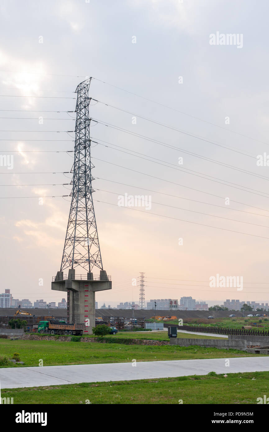 Lignes à haute tension, tour de transmission, l'électricité pylône élevé sur base de colonne en béton, la rivière Tamsui riverside, Luzhou, Taipei, Taiwan Banque D'Images