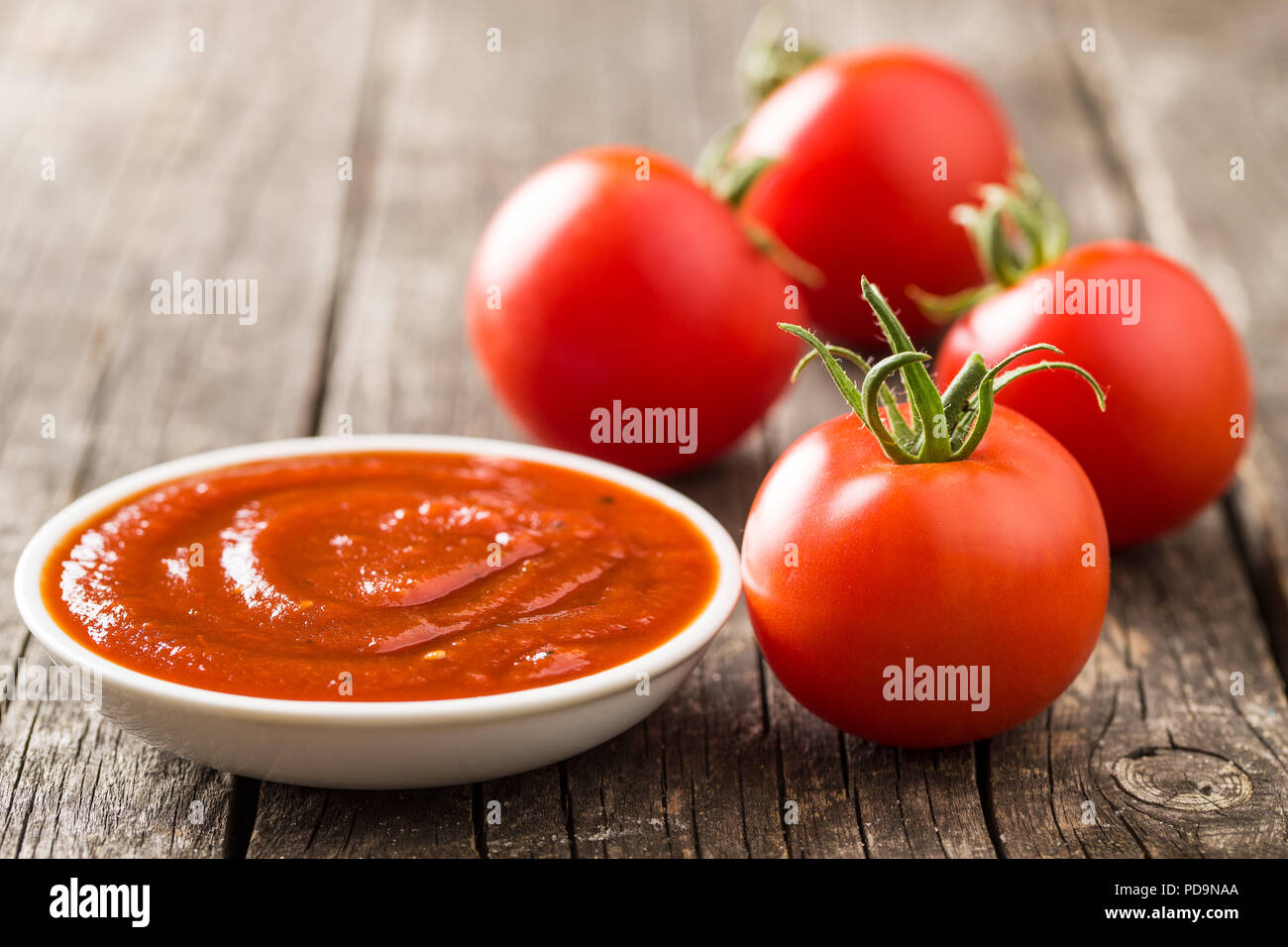 La tomate et le ketchup sur la vieille table en bois. Banque D'Images
