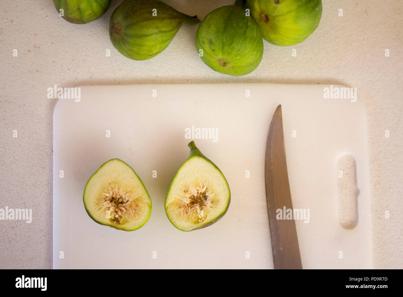 Vue de dessus les figues vertes sur tableau blanc, couteau, tranche de fig, ripe fig Banque D'Images