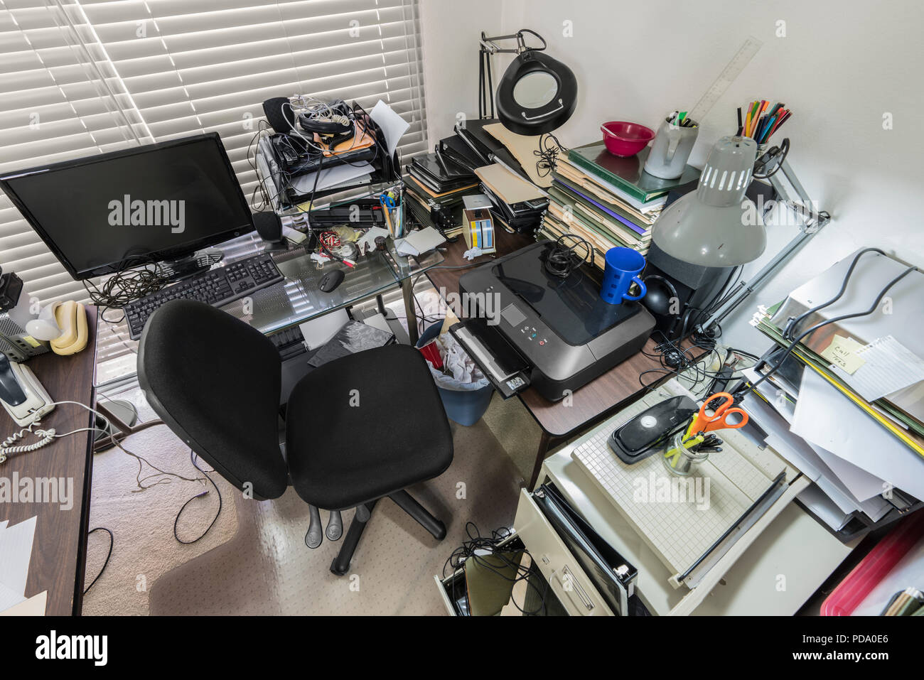 Bureau bureau avec des piles de dossiers et désorganisé l'encombrement. Banque D'Images