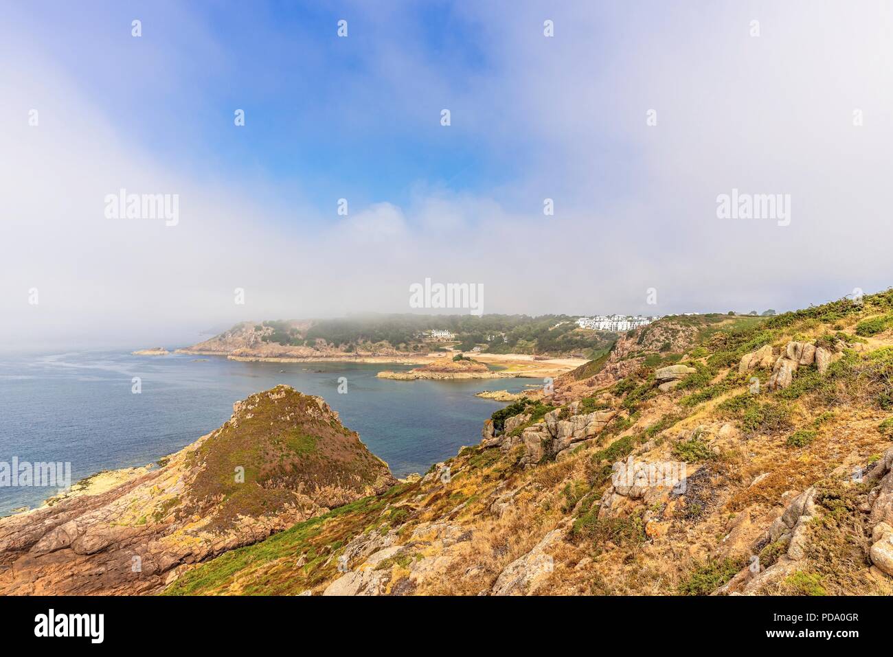 Portelet Bay à partir de la falaise à Noirmont Point dans le New Jersey. Une enveloppe de brouillard commence à l'autre pointe. Banque D'Images