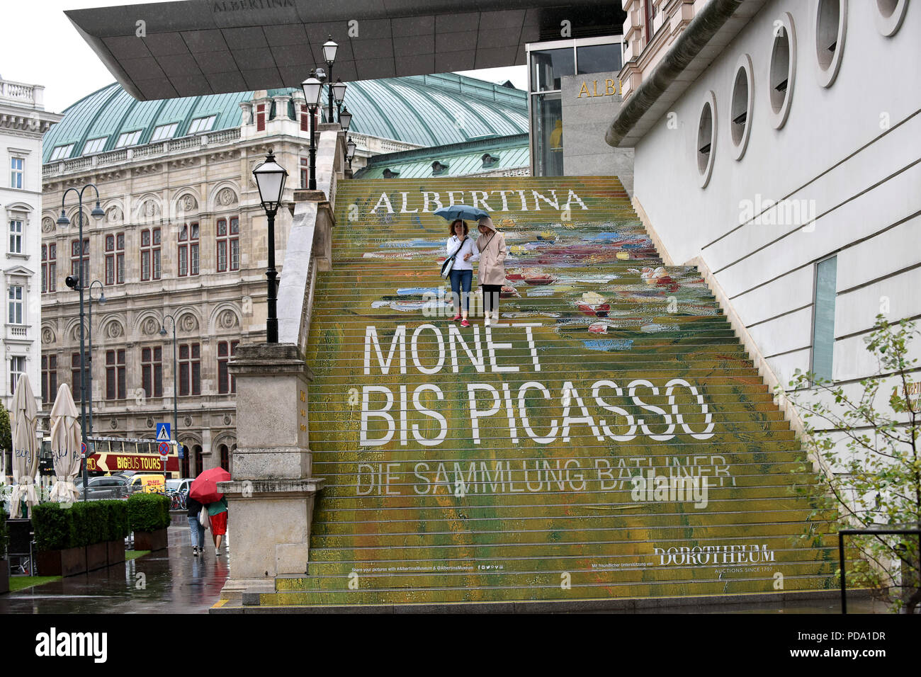 Couple dans la pluie sur les marches de l'Albertina Museum de Vienne, Autriche Banque D'Images