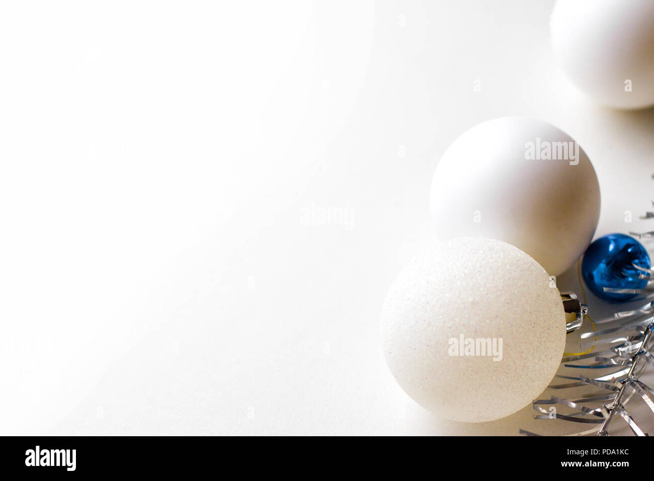 Vacances d'hiver, et la célébration de Noël - concept et carte de nouvel an avec trois boules blanches et argent tresse. copyspace Banque D'Images