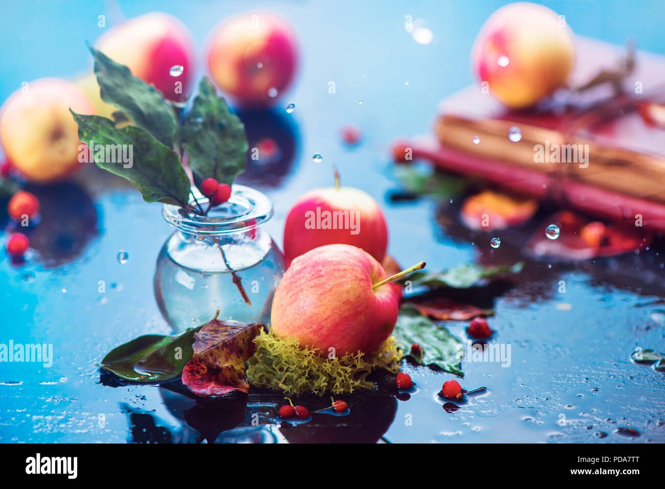 Les pommes d'automne encore la vie. En-tête de récolte d'automne sous la pluie avec des gouttes d'eau et de l'espace de copie. Les petites pommes rouges organiques avec un verre ranet jar et de feuilles mortes Banque D'Images