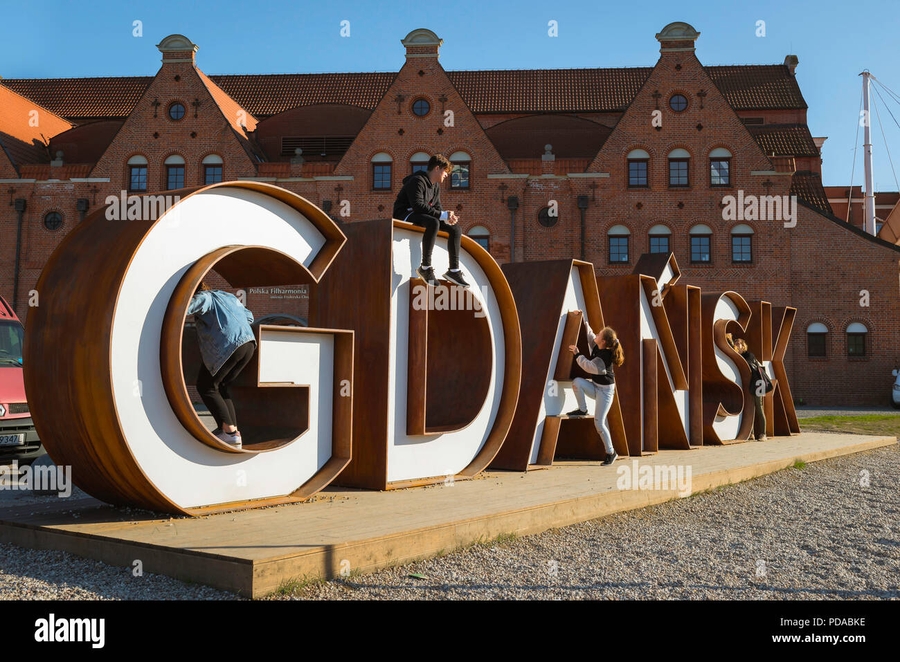 Gdansk Pologne signe, les jeunes jouent sur un énorme panneau situé à côté de la Gdansk Philharmonic Hall sur l'Île Olowianka, ville de Gdansk, occidentale, en Pologne. Banque D'Images