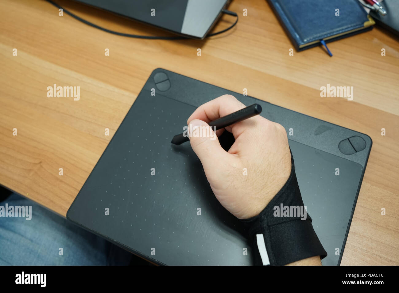 Vue ci-dessus de l'homme main designer freelancer utilisation tablette graphique avec écran tactile et stylet in office Banque D'Images