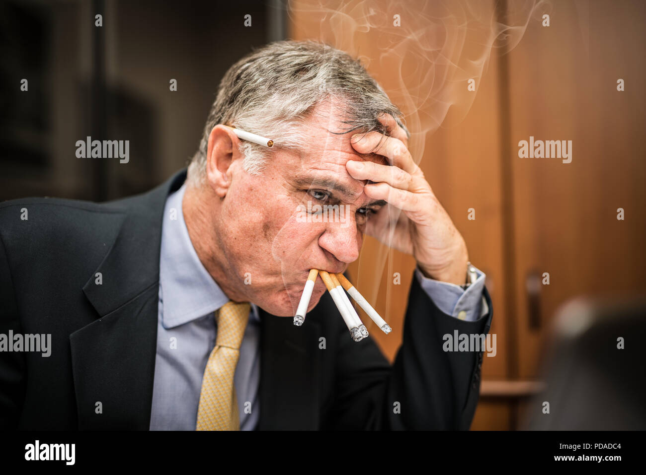 Businessman smoking nerveux beaucoup de cigarettes à la fois Banque D'Images