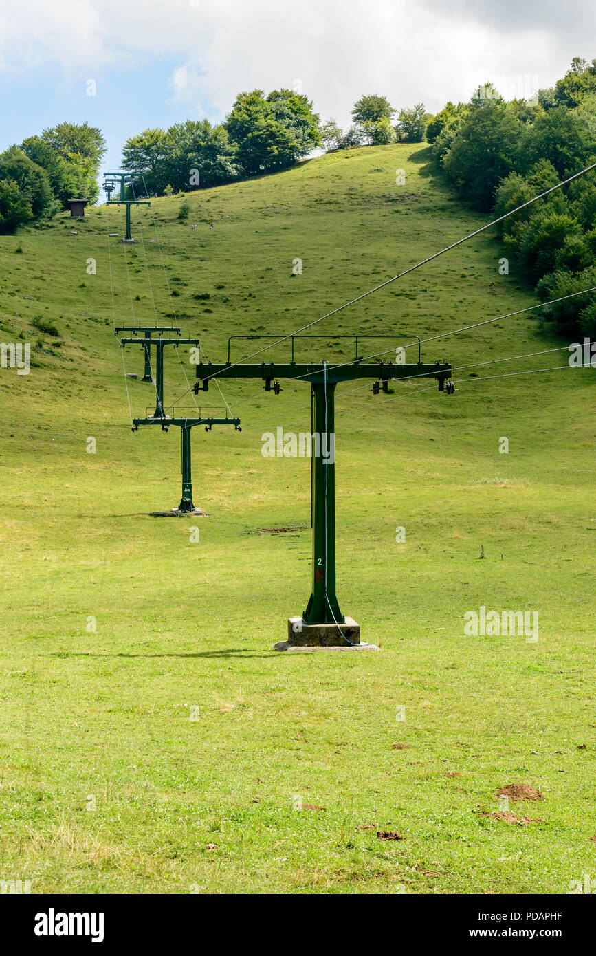 Pays vert paysage avec ascenseur de ski sur pistes vertes run, tourné dans des conditions de lumière d'été à Cainallo Alp, Lecco, Lombardie, Italie Banque D'Images