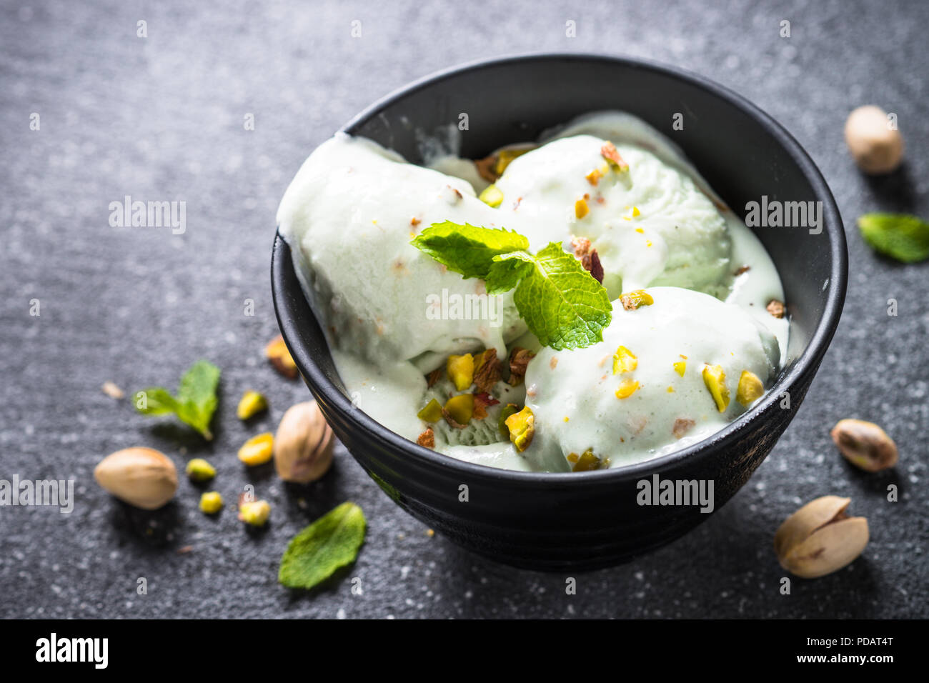 Dans un bol de crème glacée aux pistaches sur noir table de pierre. Banque D'Images