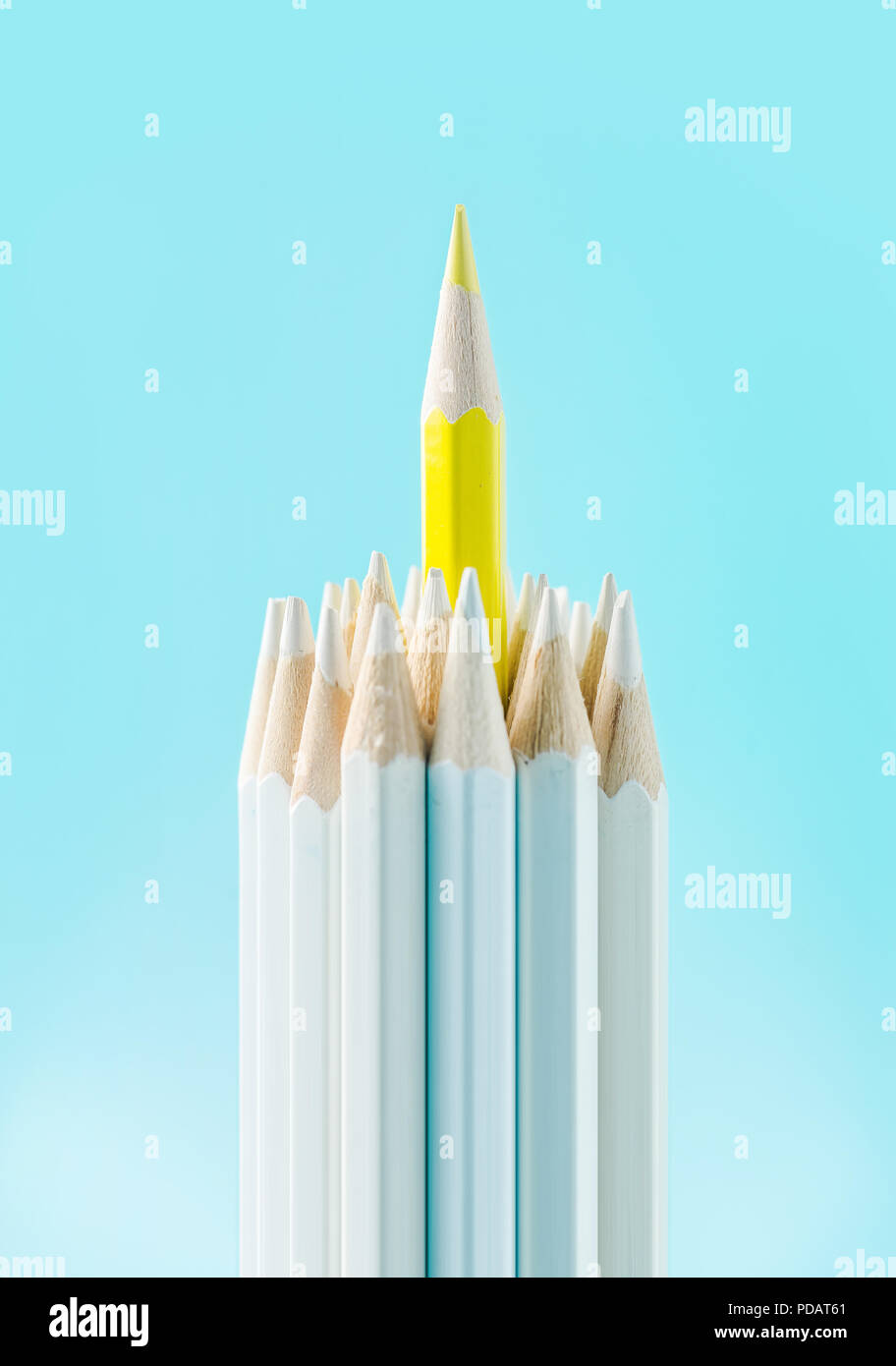 Concept d'affaires - lot de crayons blanc et un crayon de couleur sur papier bleu, l'arrière-plan. C'est symbole de leadership, le travail d'équipe, United et de communication. Banque D'Images