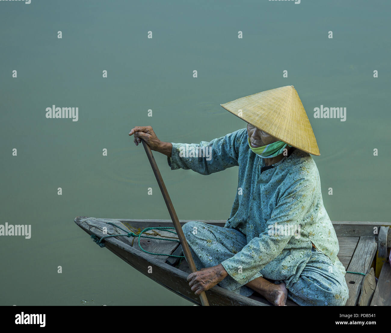 Madame asiatique en chaloupe dans un livre vert monochrome sauf pour le  beige claire chapeau conique. An Vietnam Photo Stock - Alamy