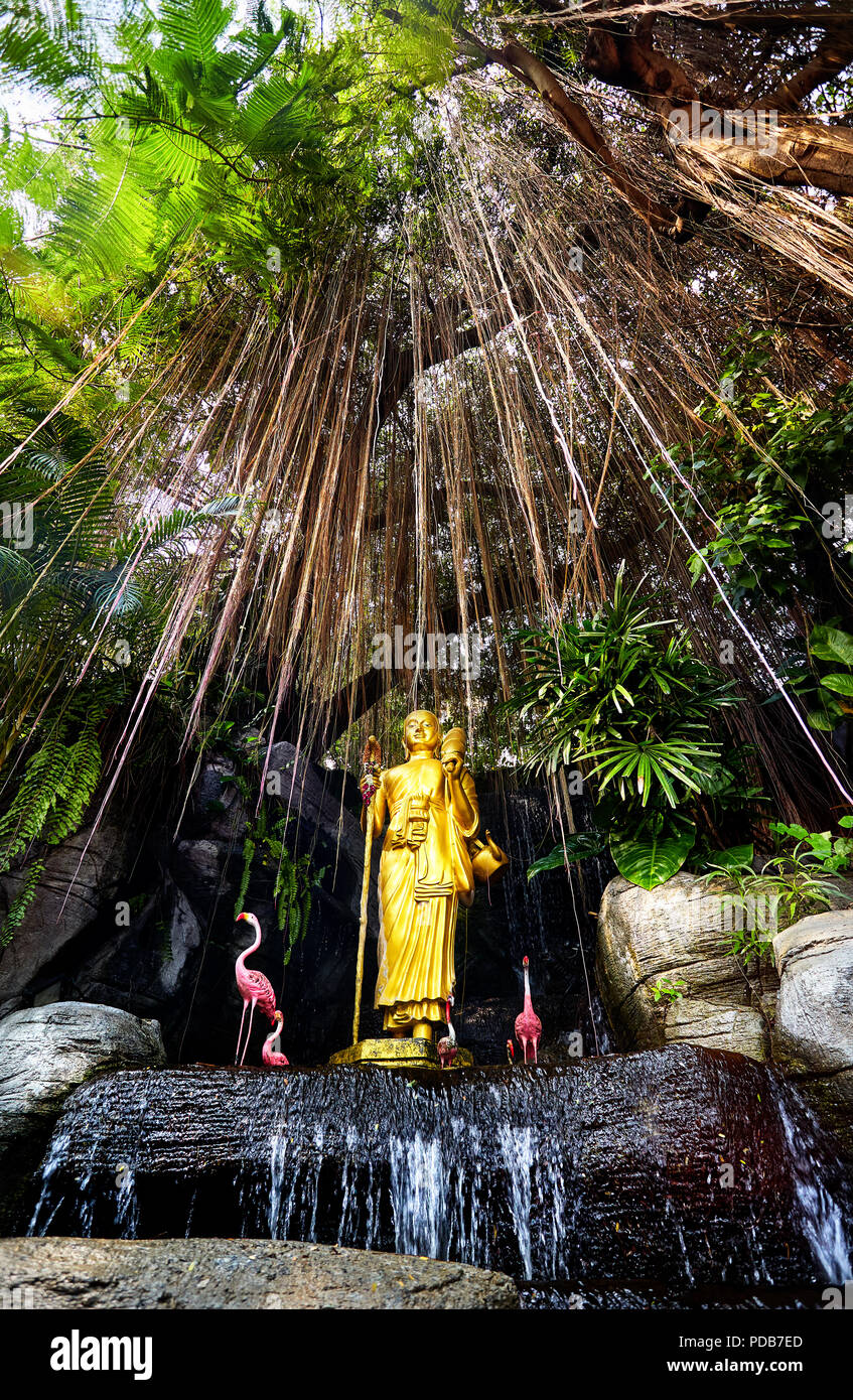 Statue du Bouddha d'or dans le jardin tropical avec une cascade dans la montagne d'Or Temple Wat Saket à Bangkok. Position verticale couvrir Banque D'Images