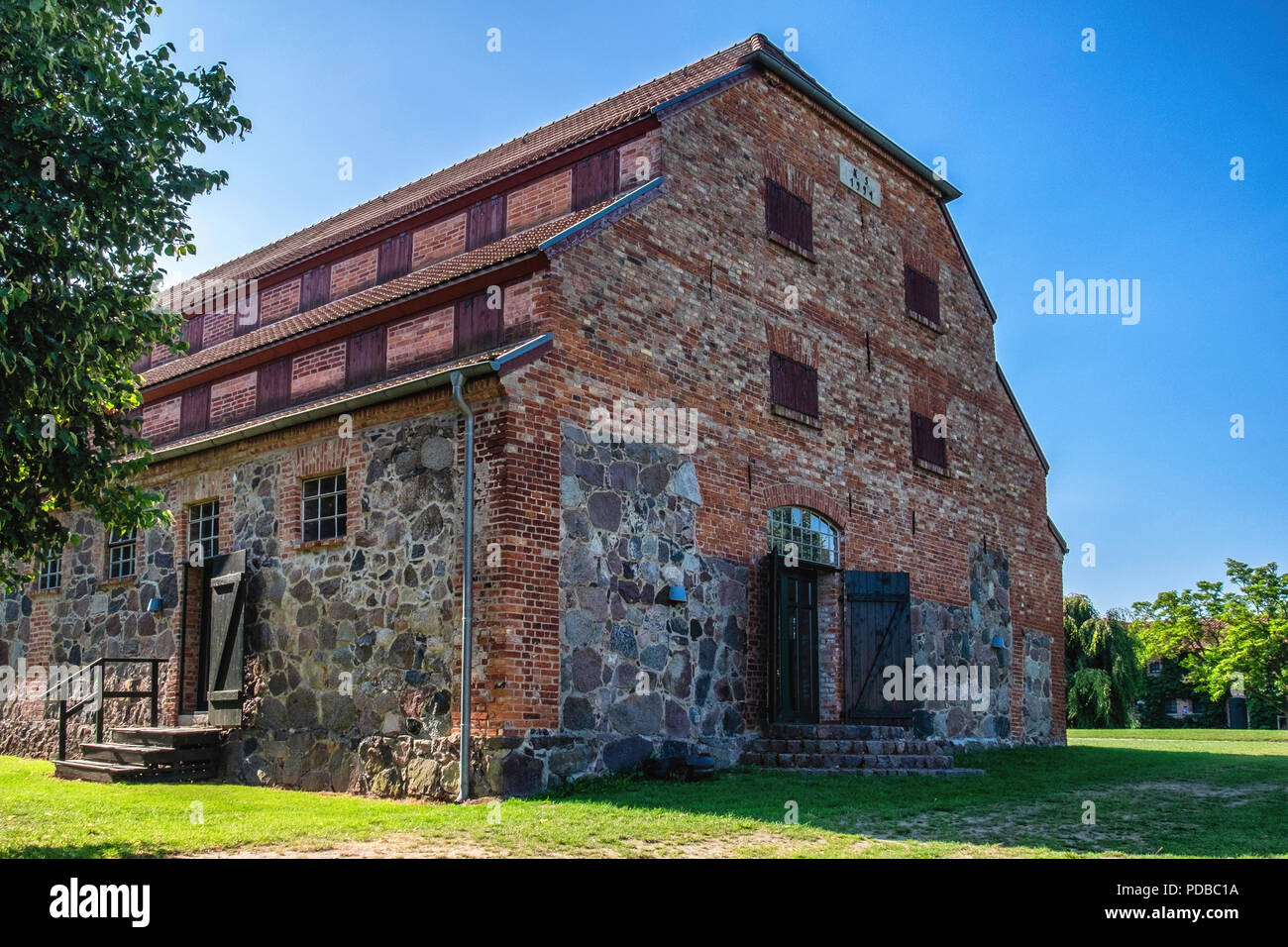 Allemagne, Hamburg an der Gutshaus Stolpe Peene, succession. Vieille ferme restaurée. Ancienne grange en pierre et en brique avec des portes de grange. Banque D'Images