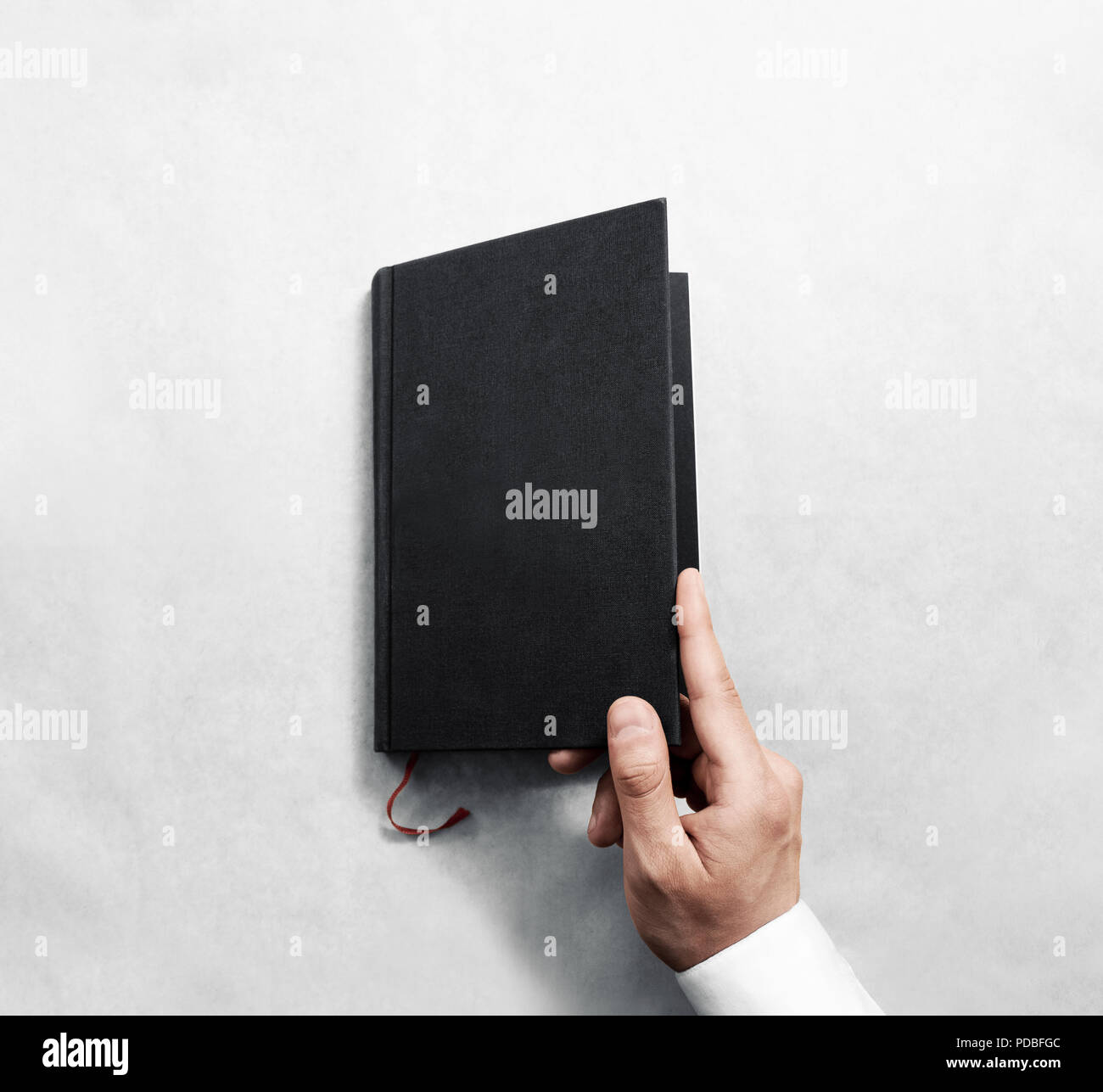 L'ouverture de la couverture du livre noir en blanc modèle maquette. Livret clair/surface Design des maquettes. Bras tenant ouvert journal manuel. Ordinateur portable gris lecture copie. Présentation Catalogue fermé. Banque D'Images