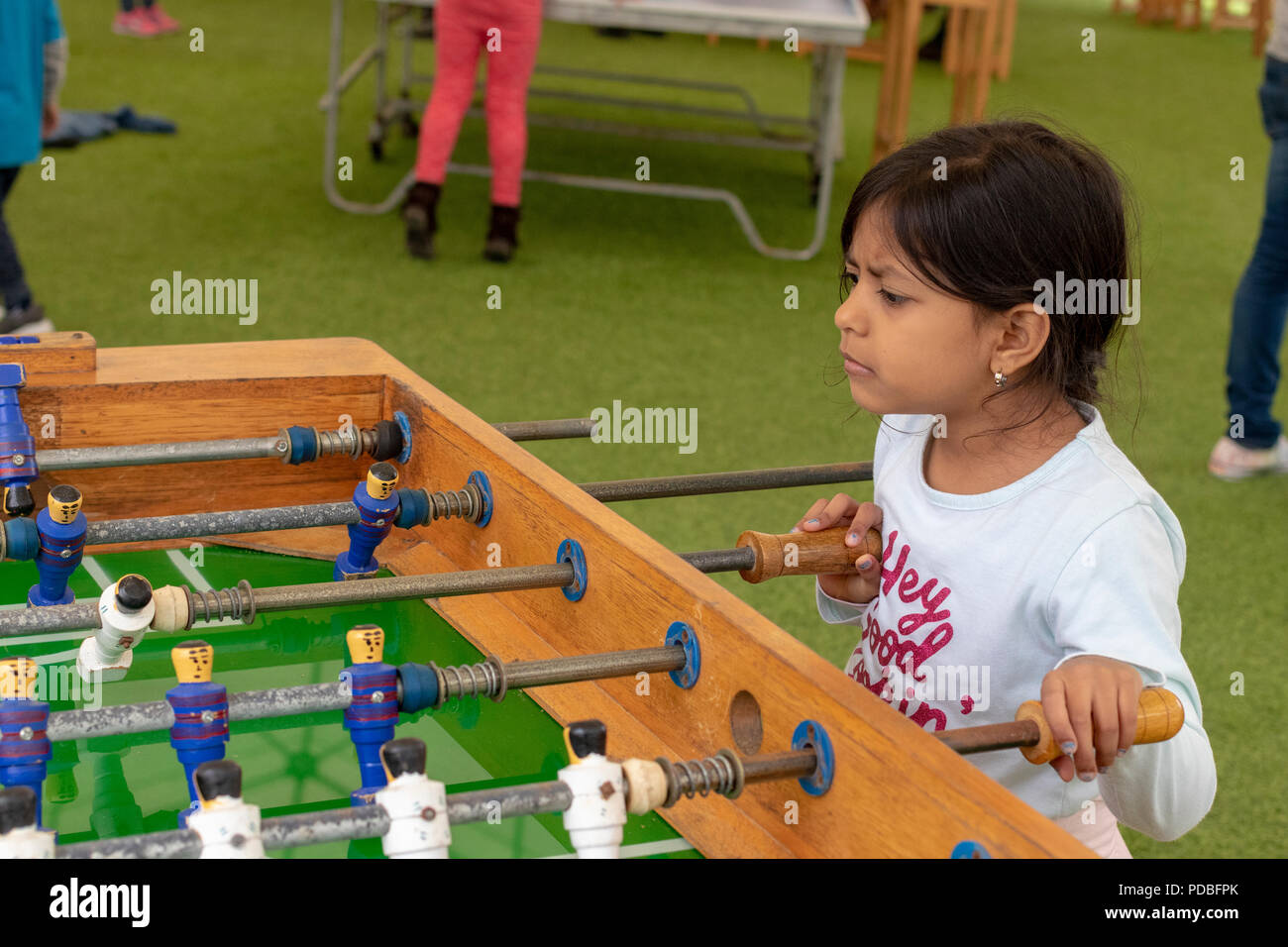 Cute little girl playing table football dans le parc Banque D'Images