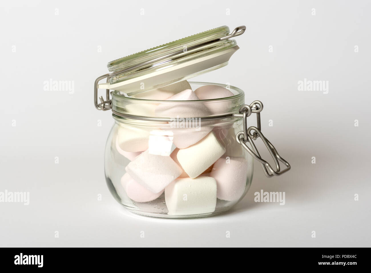 Bonbons guimauve rose et blanche en haut du clip VERRE Pot de rangement alimentaire isolé sur fond blanc Banque D'Images
