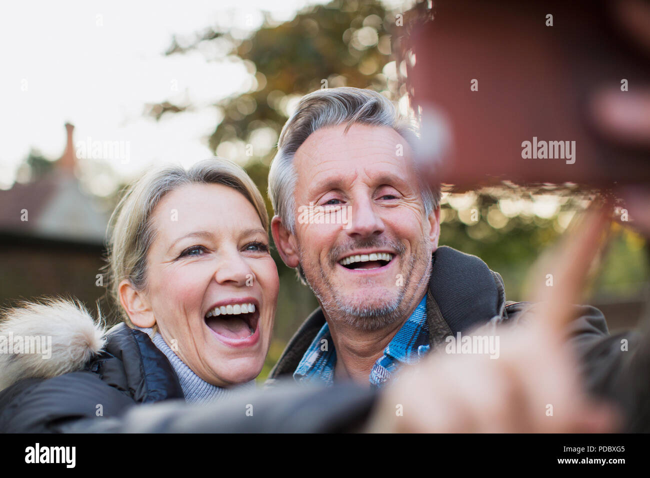 Heureux, ludique d'âge mûr en tenant selfies Banque D'Images