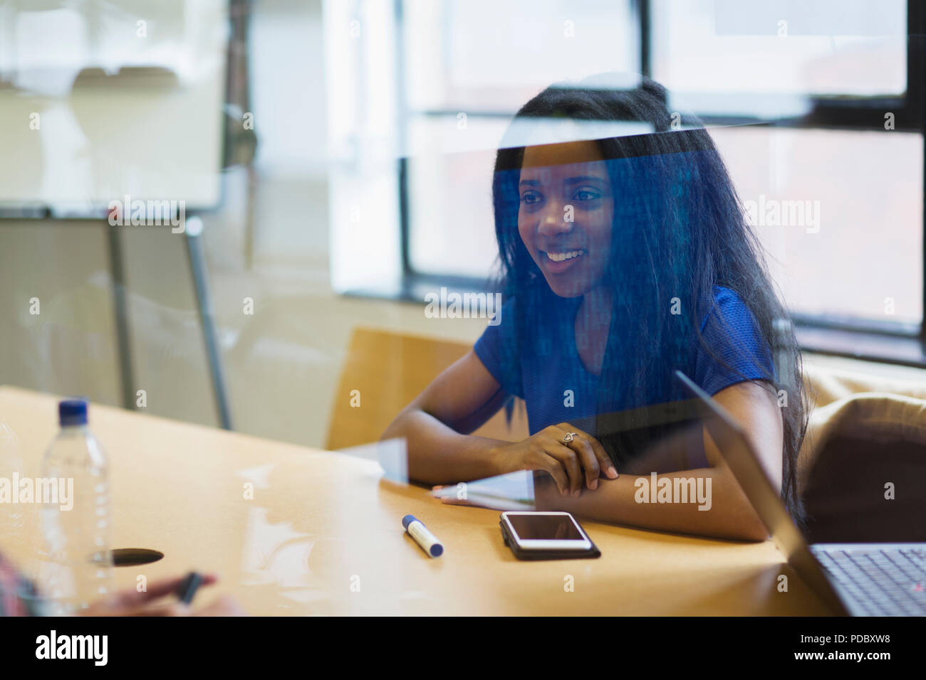 Smiling young businesswoman with smart phone en séance d'écoute Banque D'Images