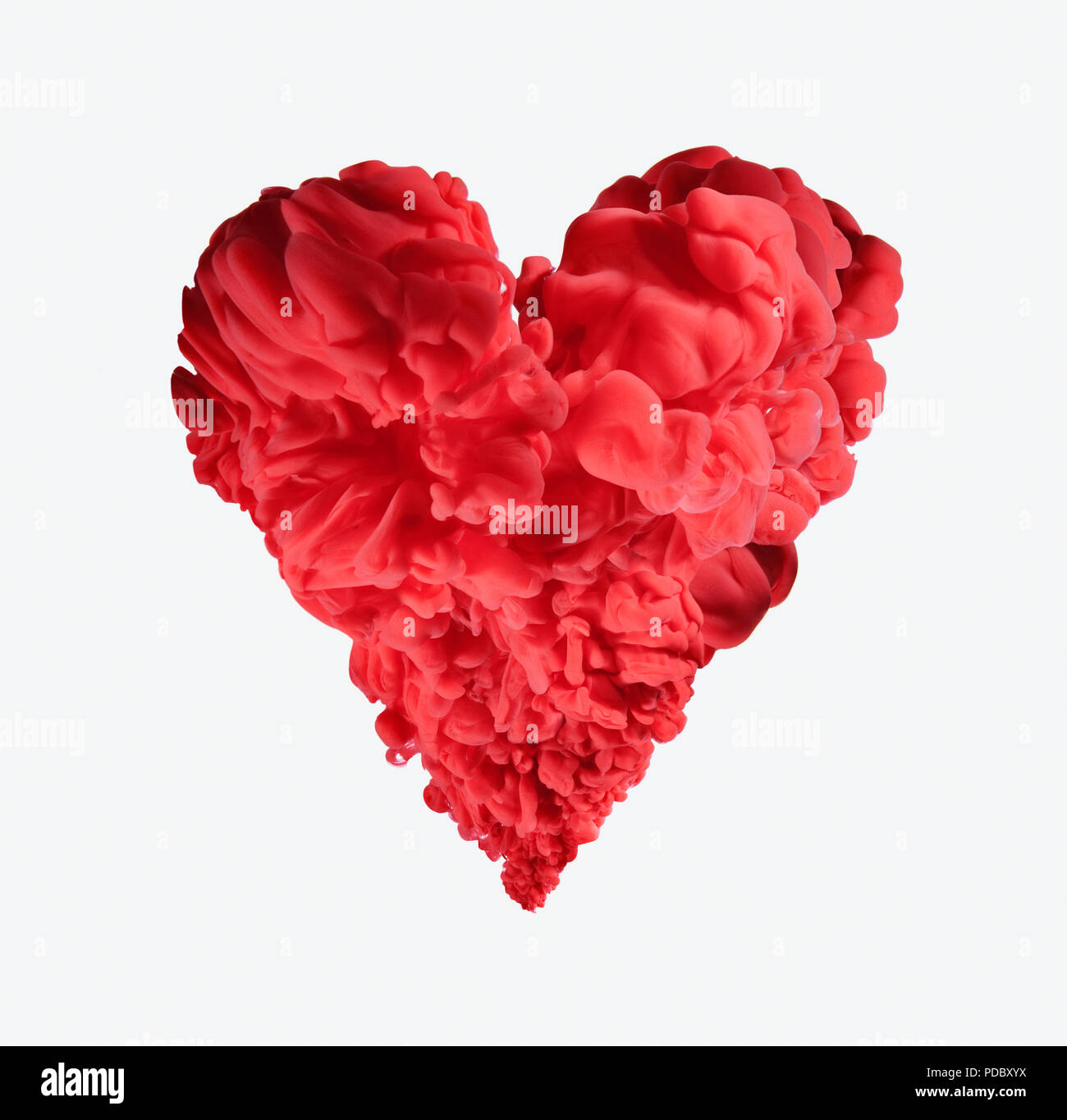 La formation d'encre rouge en forme de coeur sur fond blanc Banque D'Images