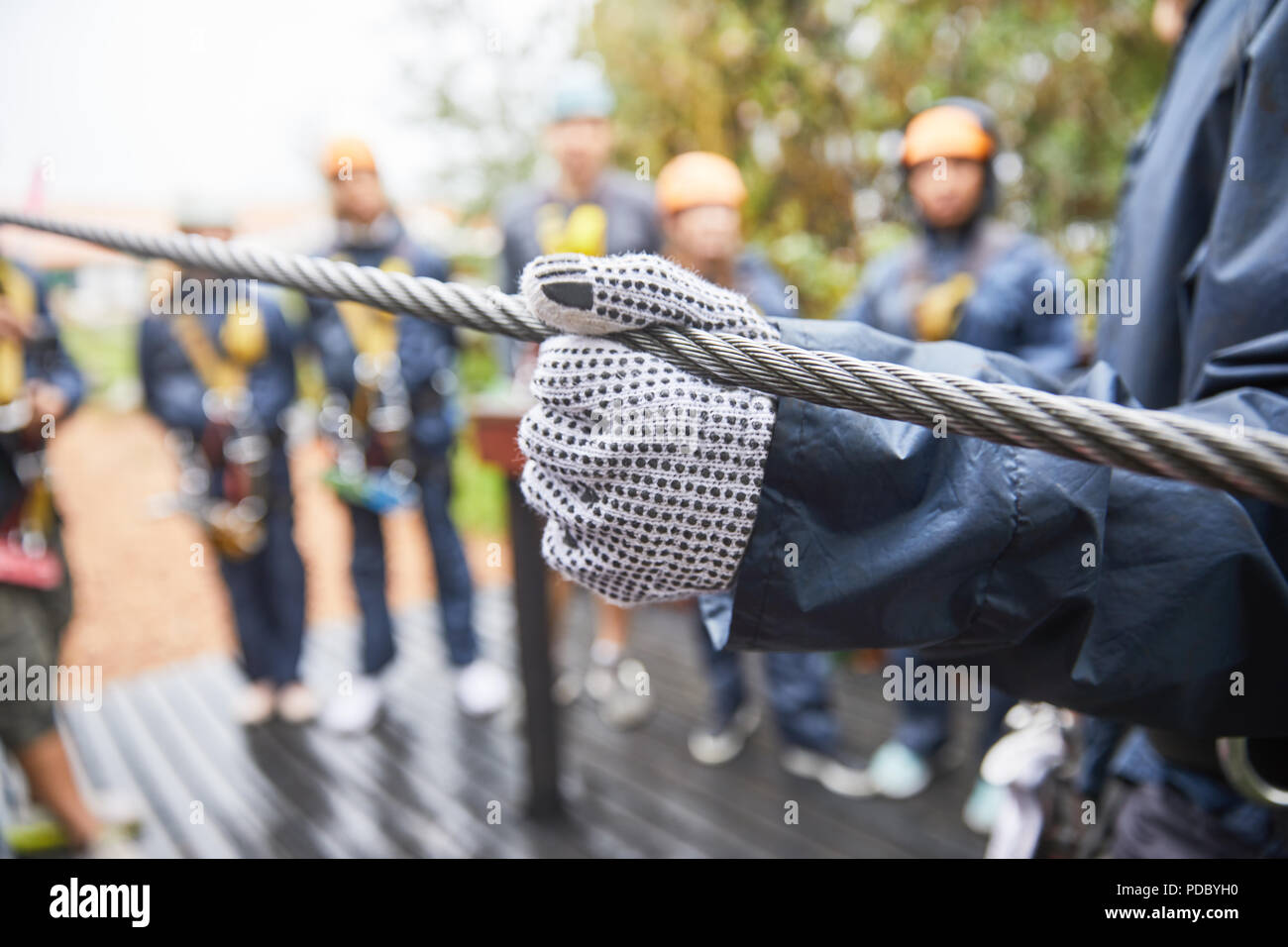 Woman in glove holding zip line Banque D'Images