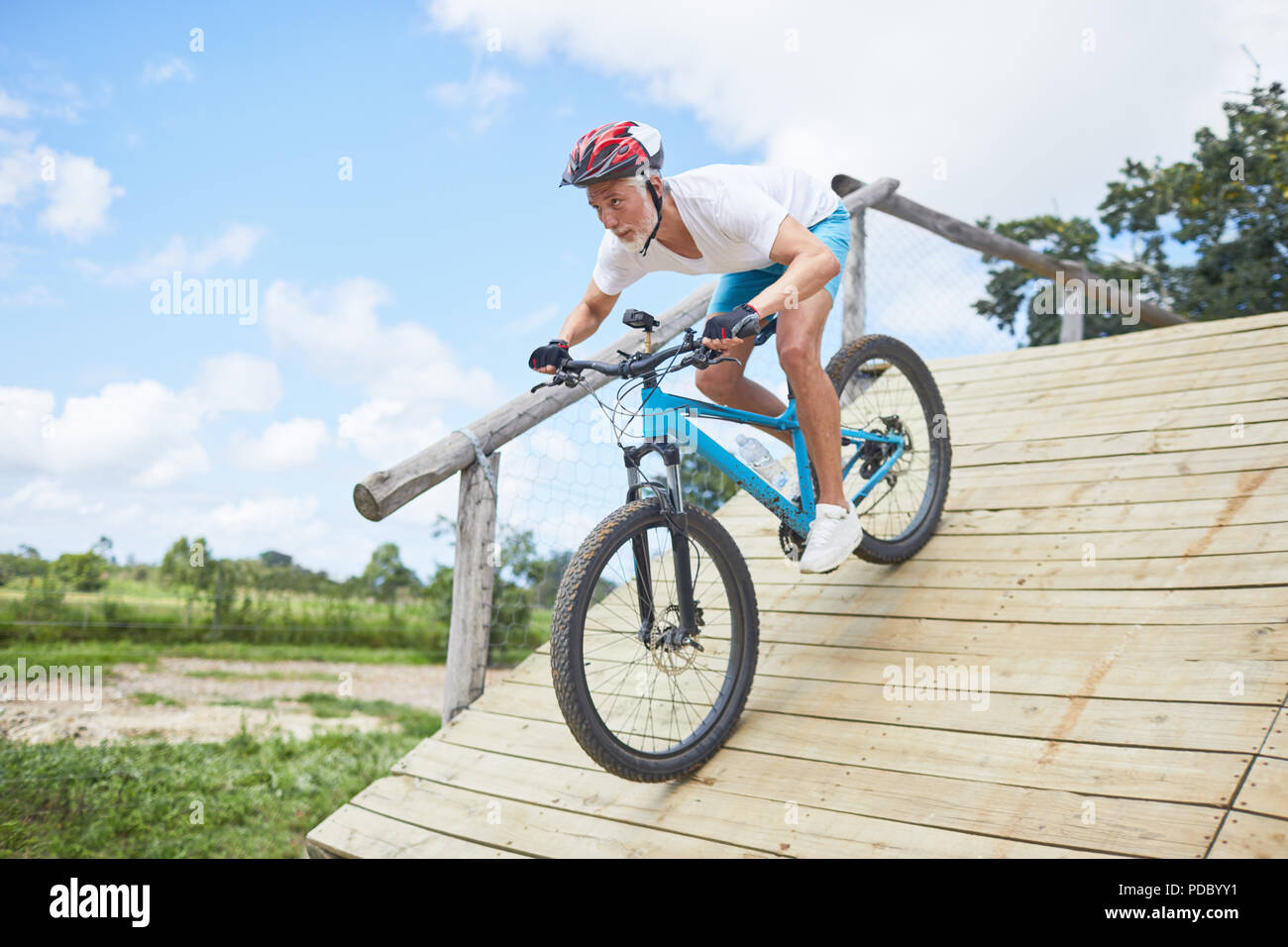 Focused mature man mountain biking bas rampe parcours Banque D'Images