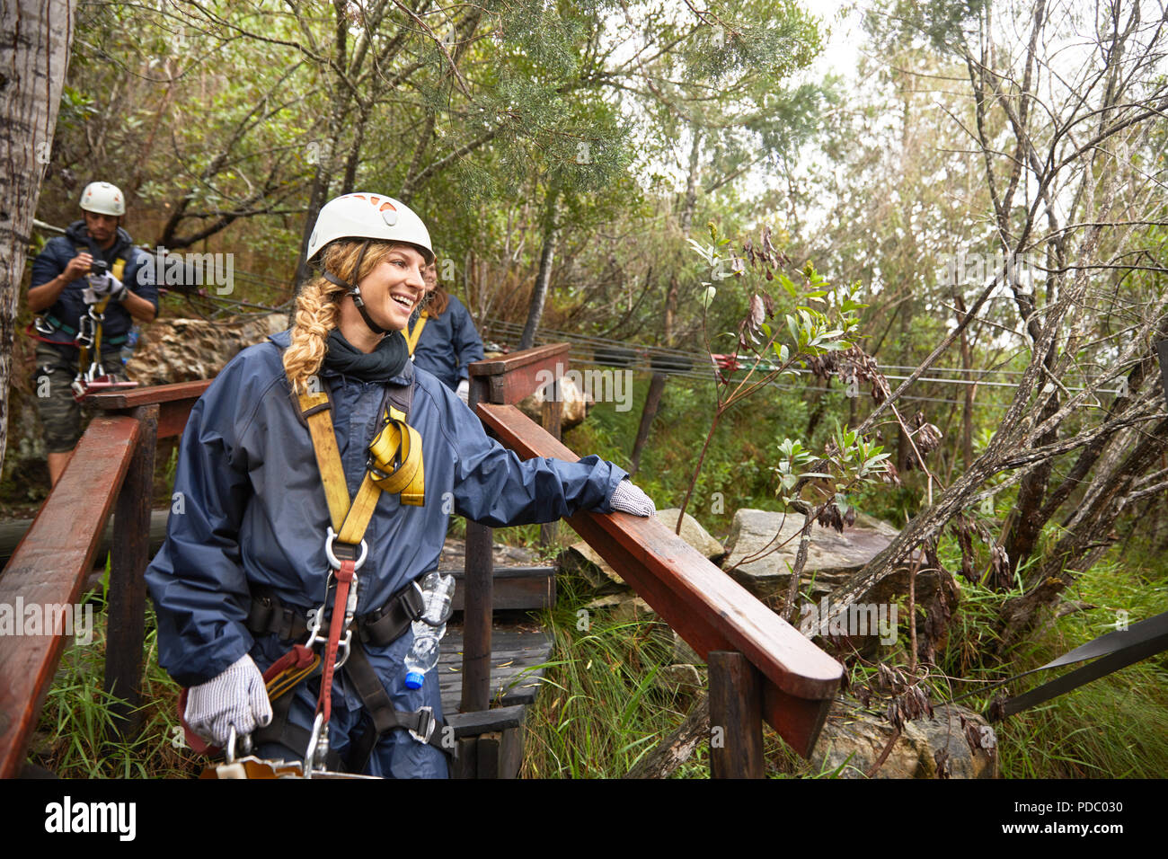 Smiling woman preparing to zip line in woods Banque D'Images Smiling woman preparing to zip line in woods Banque D'Images