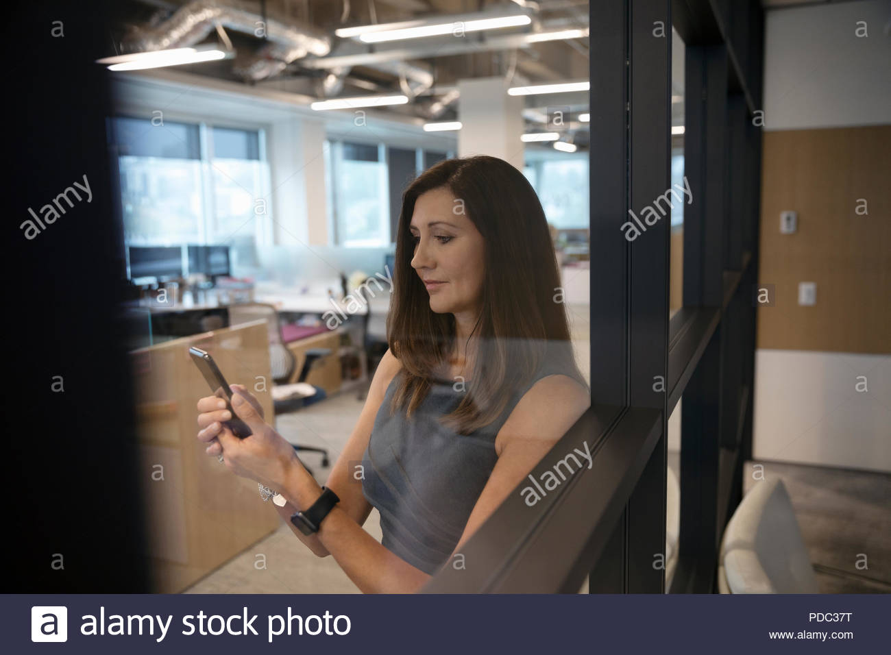 Businesswoman using smart phone in office Banque D'Images