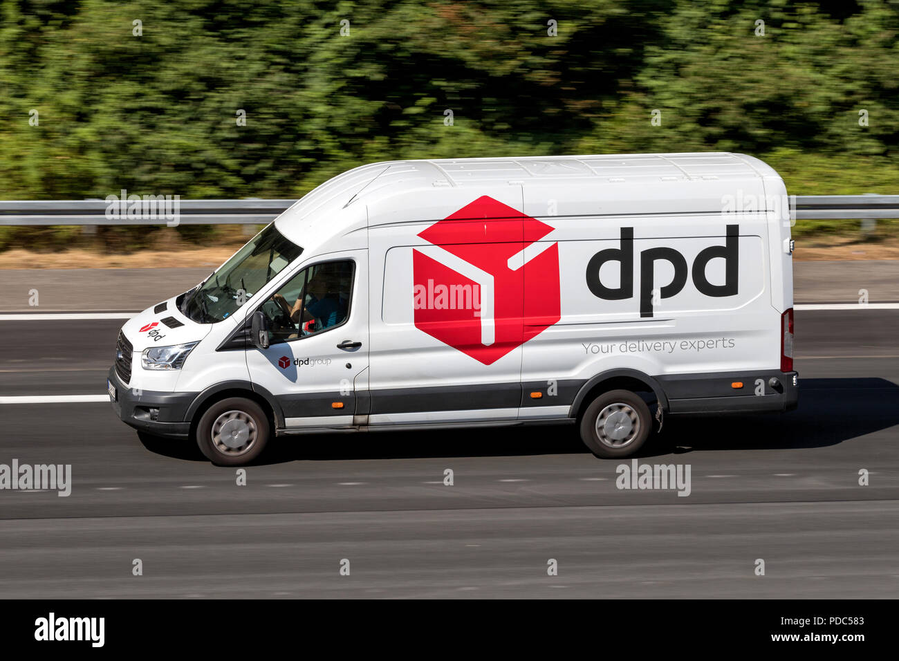 Camion de livraison DPD sur autoroute. DPDgroup est le réseau de livraison de colis international appartenant à l'Etat français le service postal, La Poste. Banque D'Images