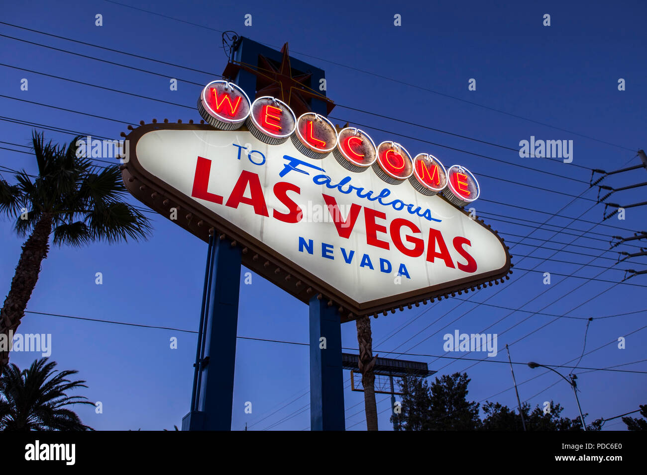 Panneau Welcome to Fabulous Las Vegas, palmiers et caténaire profil de nuit. Banque D'Images