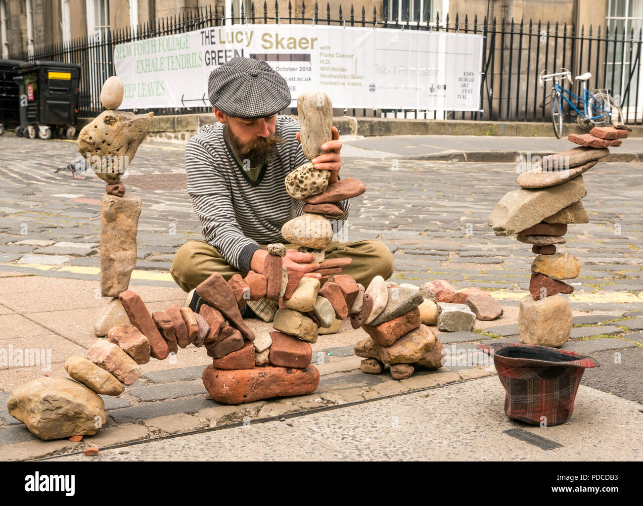 Edinburgh Fringe Festival, Édimbourg, Écosse, Royaume-Uni. 8 août 2018. Une pierre empilées, Sterling Gregory, construit en pierre des créations de pile sur la chaussée pendant le Edinburgh Fringe Festival. L'homme est en train de construire des tours de pierre et d'arches près d'une grande enseigne où l'art et la collecte de dons dans un chapeau Banque D'Images