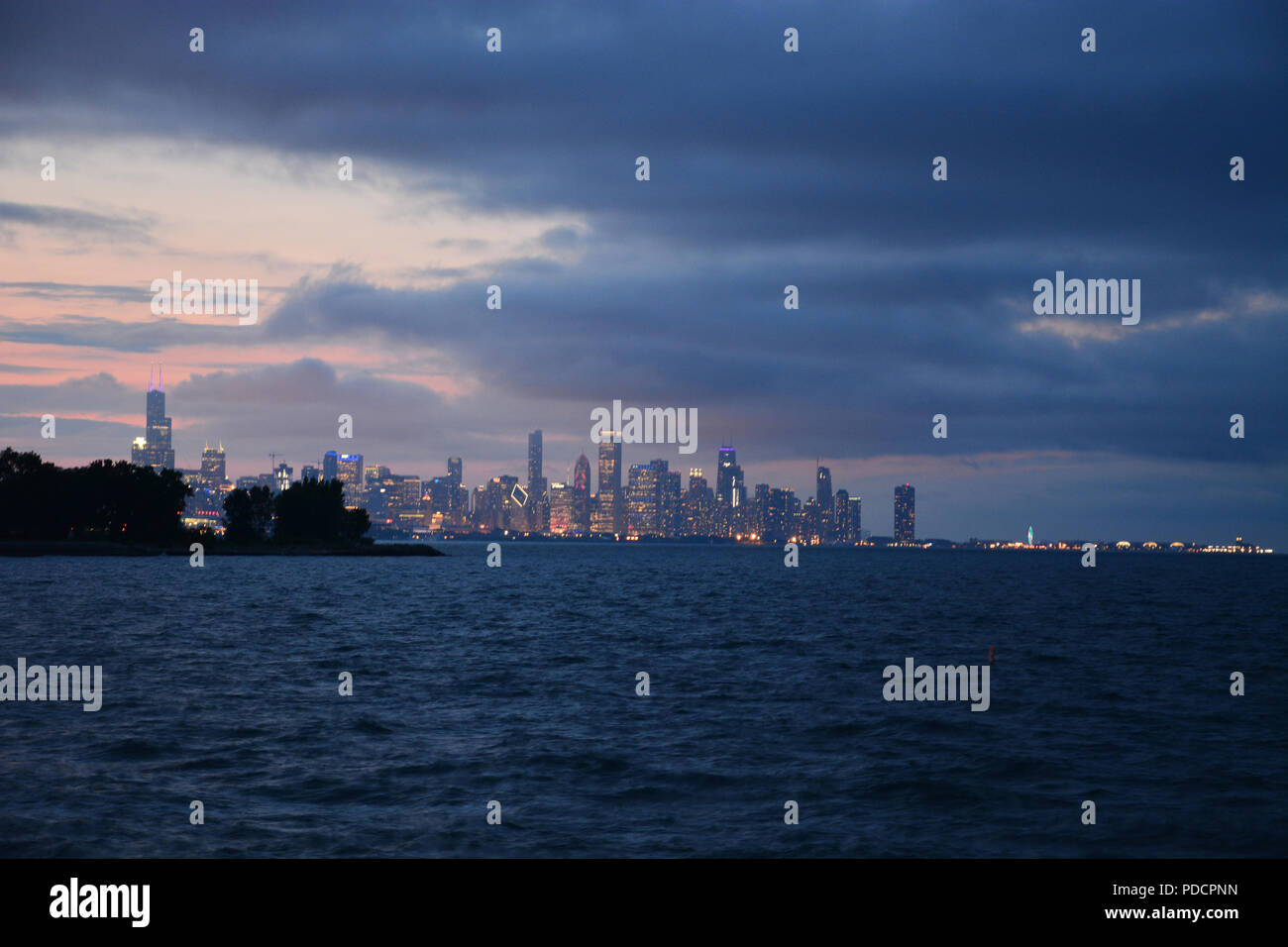 Vue de l'horizon de Chicago sur l'horizon rougeoyant sur le lac au crépuscule de Promontory Point dans le quartier de Hyde Park sur le côté sud. Banque D'Images