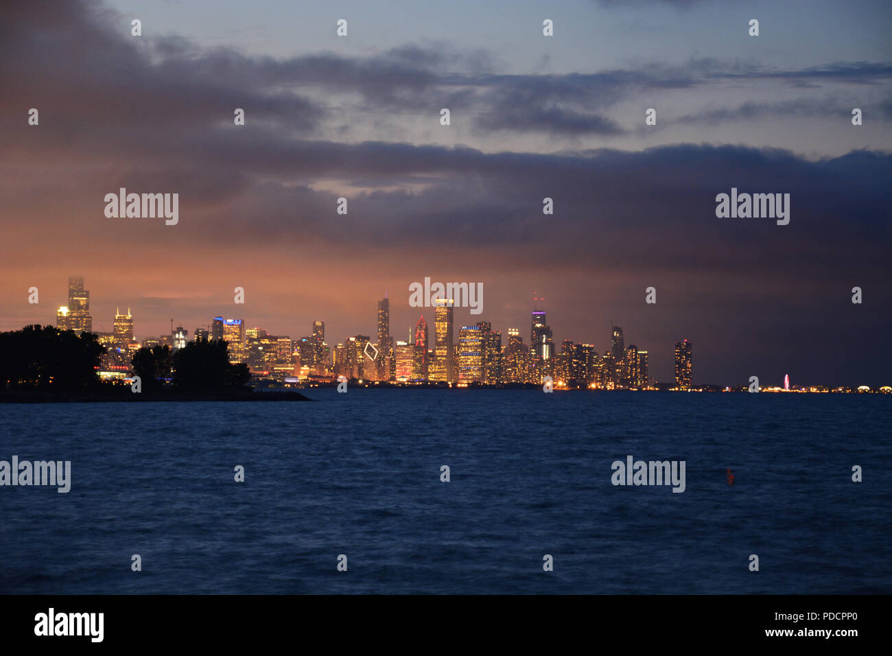 Vue de l'horizon de Chicago sur l'horizon rougeoyant sur le lac au crépuscule de Promontory Point dans le quartier de Hyde Park sur le côté sud. Banque D'Images