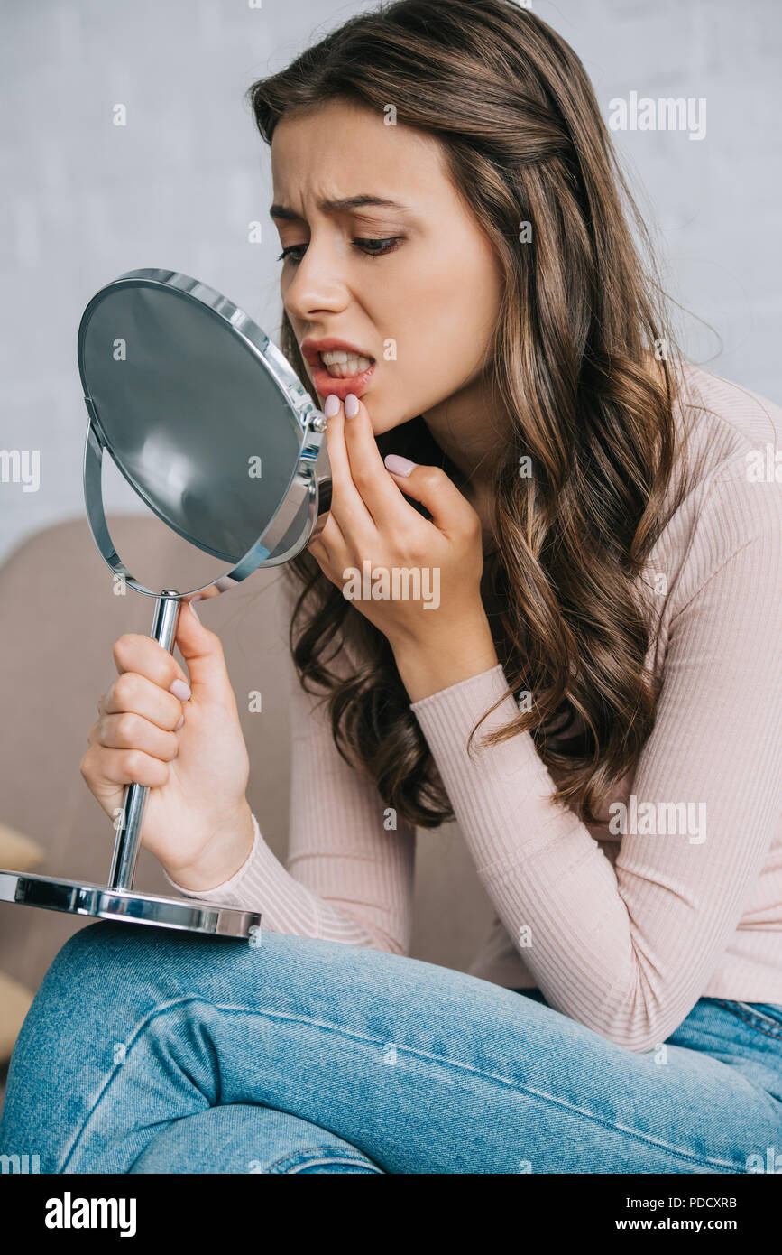 Jolie jeune femme avec la douleur de la dent et à miroir à Assise Photo  Stock - Alamy