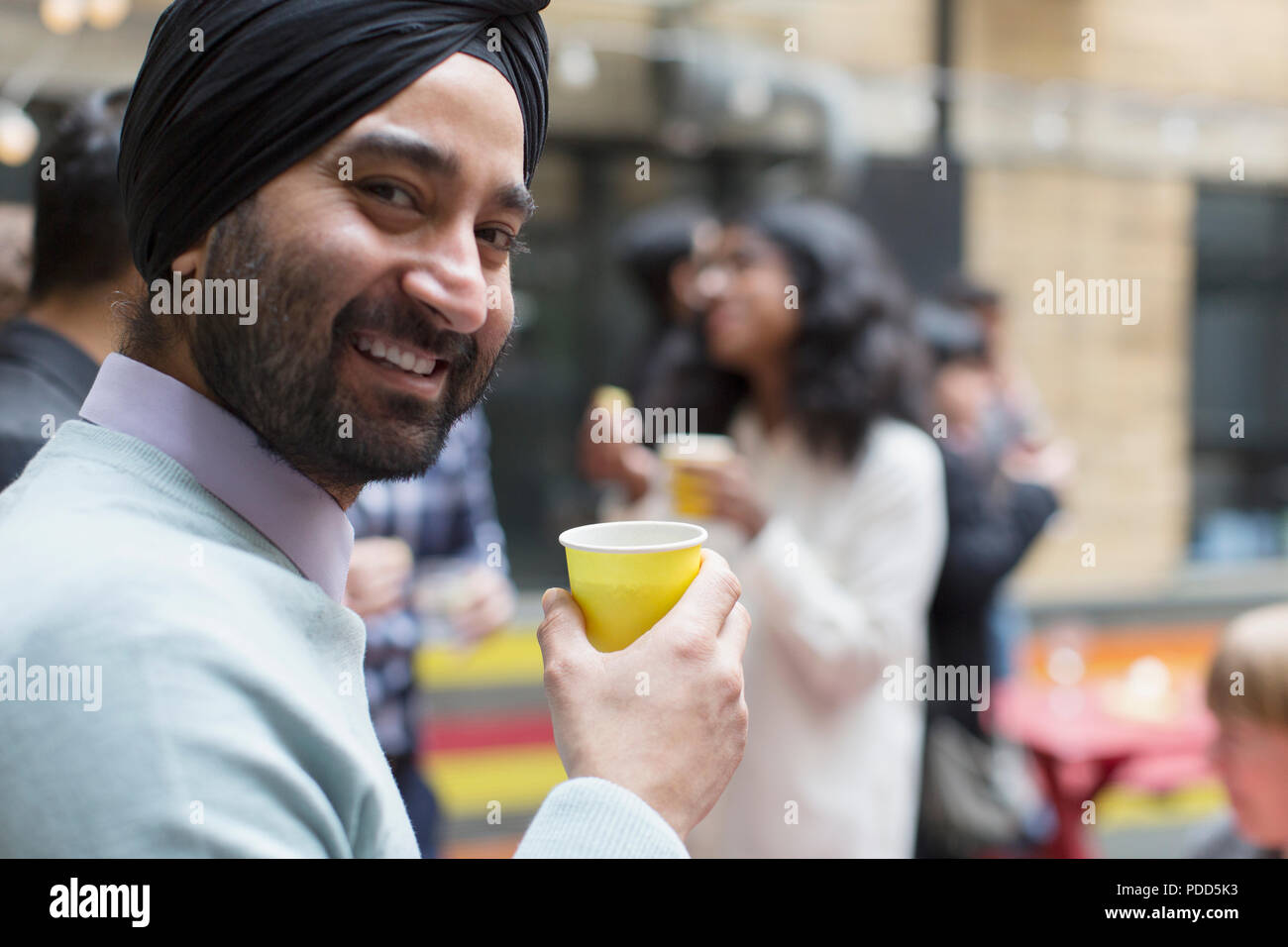 Portrait smiling man en turban de boire, enjoying party Banque D'Images